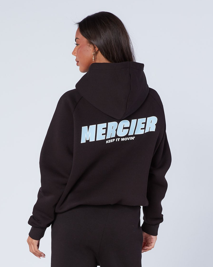 Person wearing a black hoodie with 'Mercier' branding on the back against a light gray background